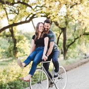 Bike ride date in the park, man pedaling bike with woman on handlebars