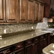 a kitchen with dark wood cabinets and granite countertops