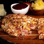 a wooden cutting board with a pizza cut in half