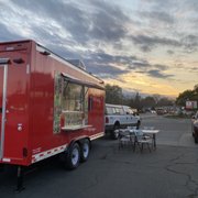 a red food truck parked in a parking lot