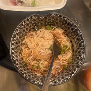 a bowl of noodles and a spoon