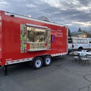 a red food truck parked in a parking lot