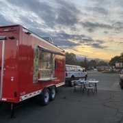 a red food truck parked in a parking lot
