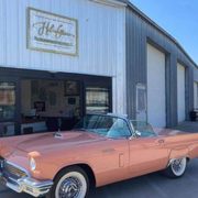 a pink car parked in front of a garage