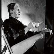 a man sitting in a chair and holding a cup