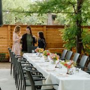 a group of people standing around a long table
