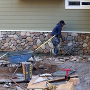 a man with a wheelbarrow in front of a house