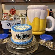a birthday cake with a mug of beer in the background