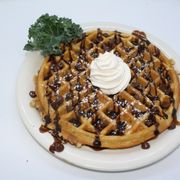 a waffle topped with whipped cream and chocolate chips