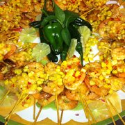 Flaming shrimp skewers with chipotle glaze, pineapple relish and candied sunflower seeds
