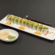 a plate of sushi and a small bowl of sauce