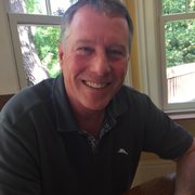 a smiling man sitting at a table